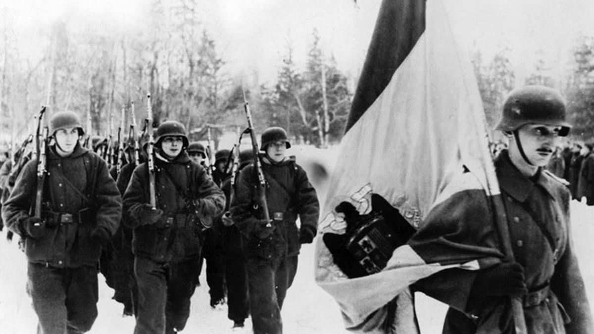 Integrantes de la División Azul, con el uniforme alemán de la 250 División de Infantería, desfila tras la bandera de la España de Franco camino de Leningrado.