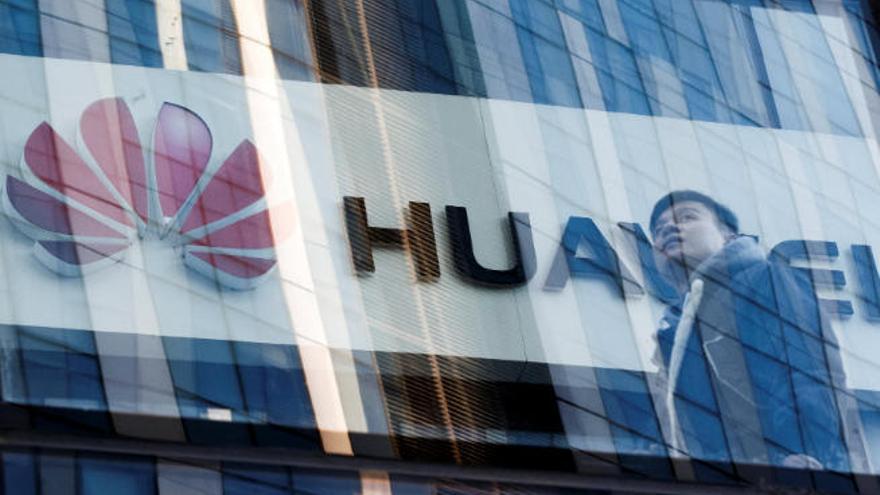 Un hombre pasa frente a una tienda de Huawei en Pekín.
