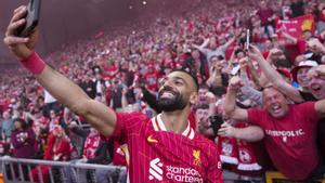 Liverpools Mohamed Salah celebrates by taking a selfie after winning the English Premier League soccer match between Liverpool and Tottenham Hotspur and clinching the Premier League title at Anfield in Liverpool, England, Sunday, April 27, 2025. (AP Photo/Jon Super)