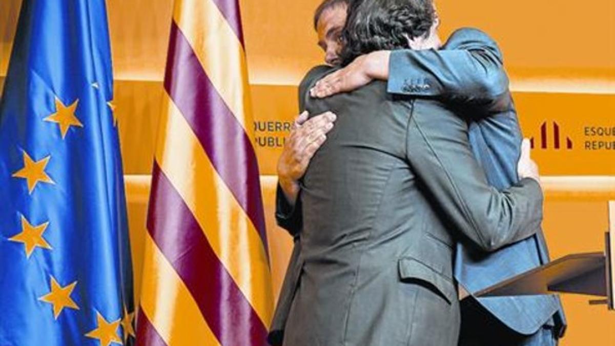 Oriol Junqueras y Jordi Portabella se abrazan tras la rueda de prensa de ayer en la sede de ERC.