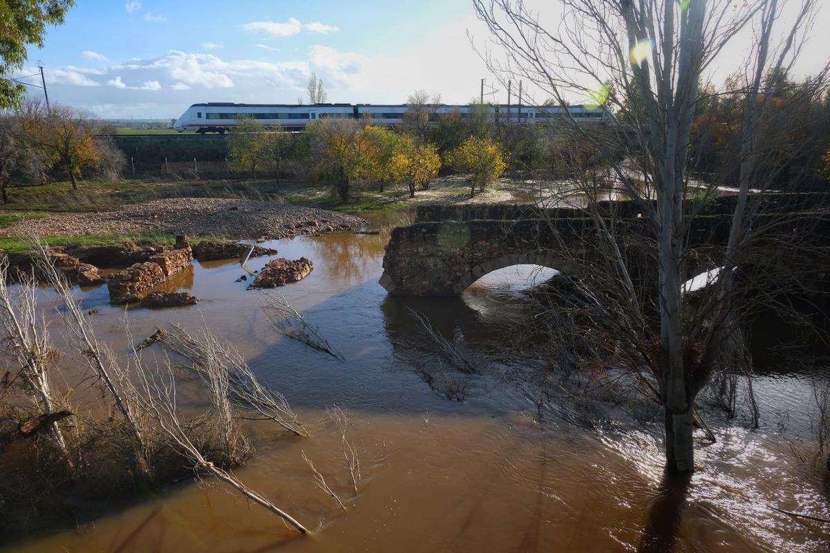 Un ciclista observa los destrozos causados por la crecida del río Gévora en el puente, hoy.