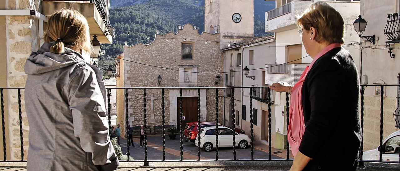 Dos vecinas de Fageca observan a otros habitantes de la localidad, este viernes. | JUANI RUZ