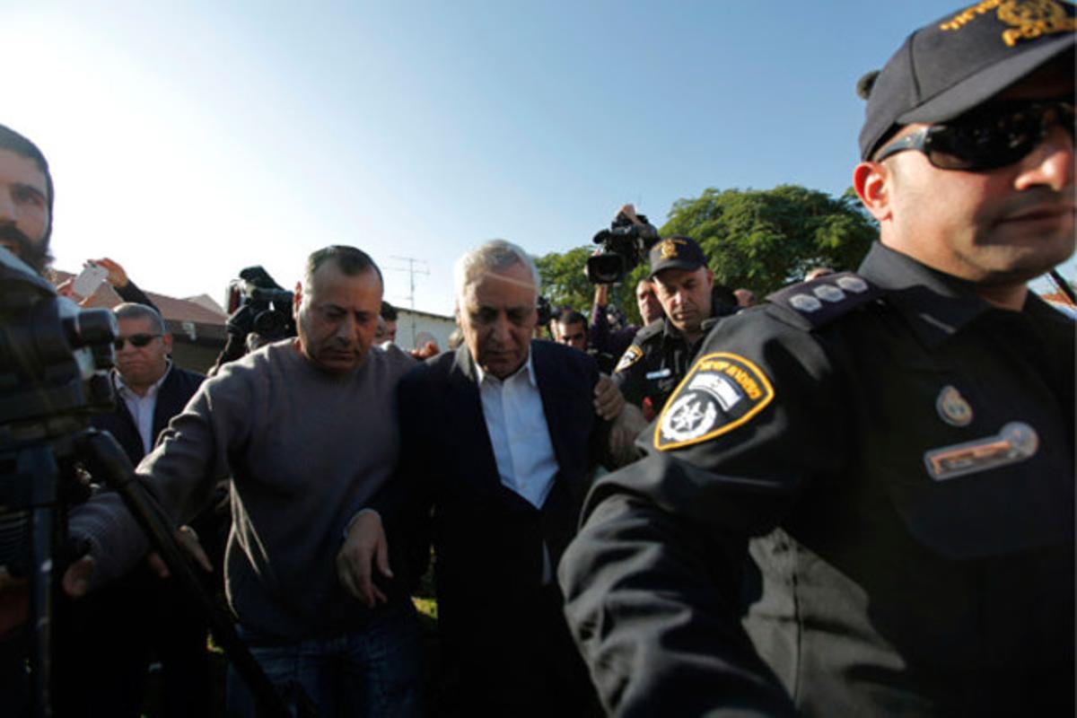 L’expresident israelià Moshe Katsav és escortat per la policia durant el trasllat des de casa seva, a Qiryat Malahi (Israel), fins a la presó de Maasiyahu, on complirà condemna per violació.