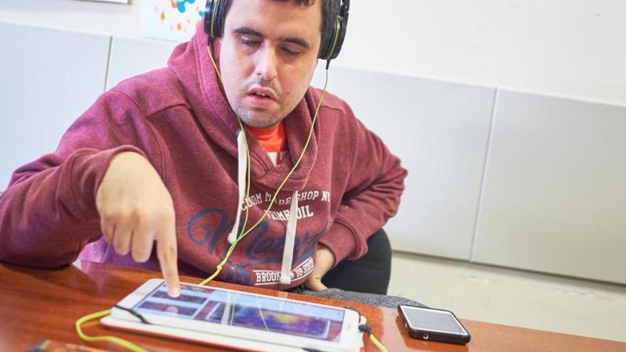 Un hombre con trastorno del espectro del autismo realiza sus tareas diarias en una tablet en las instalaciones de Apanate.