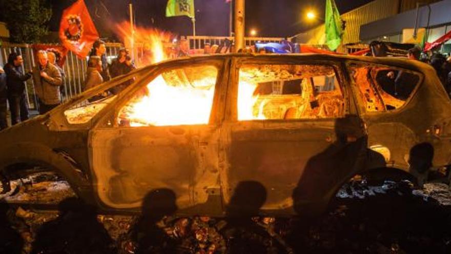 Empleados de la factoría de Genk queman un coche durante las protestas de anoche.