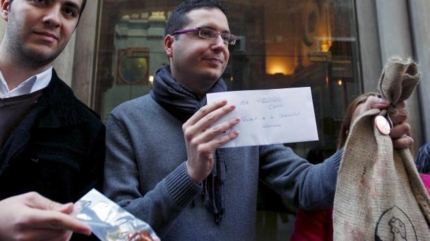 Miembros de Joves Socialistes, a las puertas de la sede de Presidencia de la Generalitat con uno de los lotes navideños.