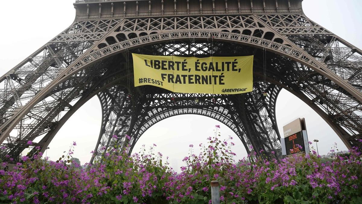 'Libertad, igualdad, fraternidad', se lee en la pancarta que Greenpeace ha colgado en la Torre Eiffel.