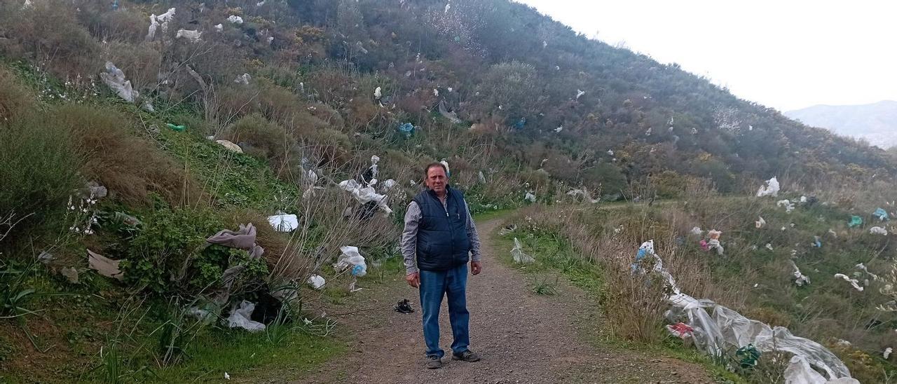 El presidente vecinal de Colmenarejo, José Ángel Moreno, detrás de un cerro cubierto de basura, la semana pasada.
