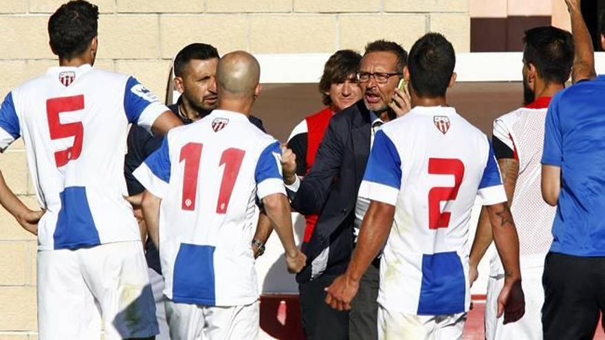 El delegado Quique Sala, teléfono en mano, informa a los jugadores de la victoria del Cornellá ante el Lleida.