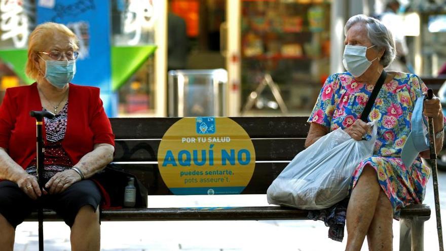 Dos mujeres conversan en un banco de L&#039;Hospitalet (Barcelona).