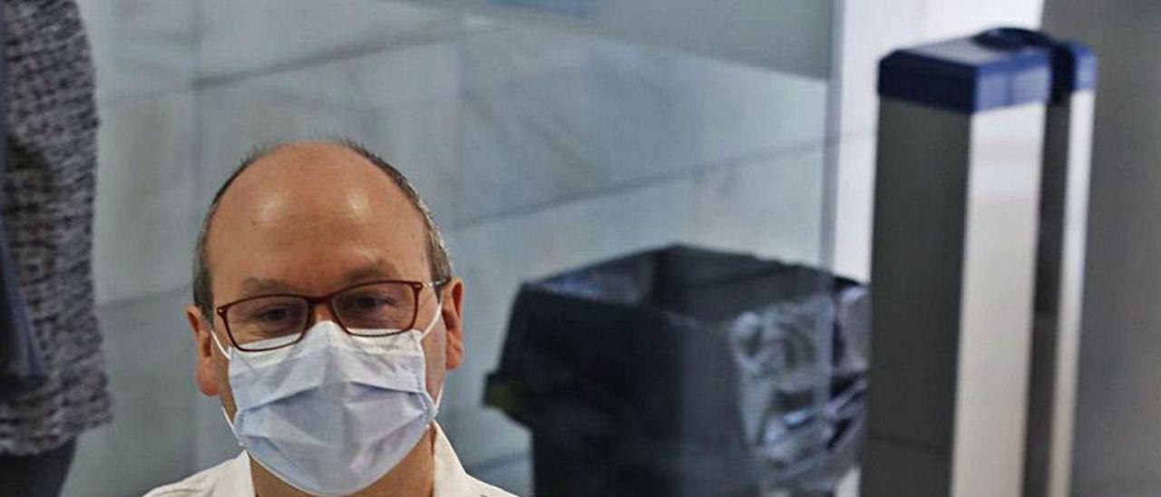 Leopoldo Álvarez, junto a una de las señales que fijan la salida en el Hospital de Cruz Roja de Gijón.