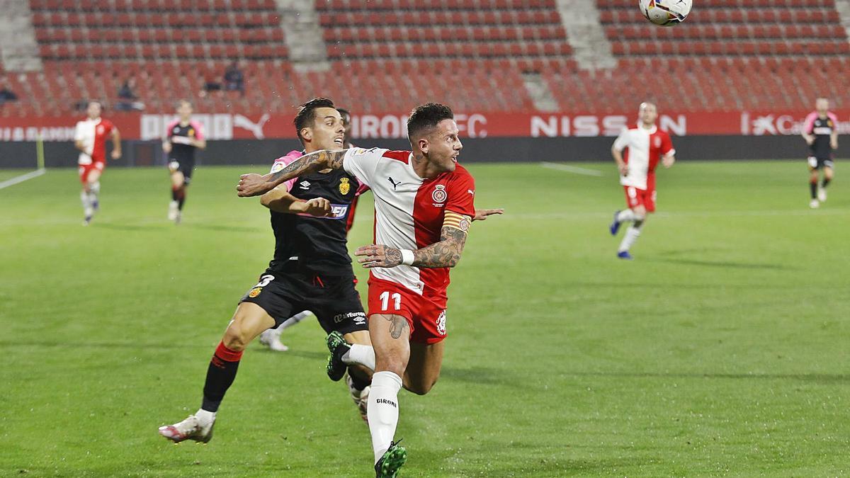 Aday Benítez protegeix una pilota davant Brian Oliván (Mallorca) durant el partit de la temporada a Montilivi.  | ANIOL RESCLOSA