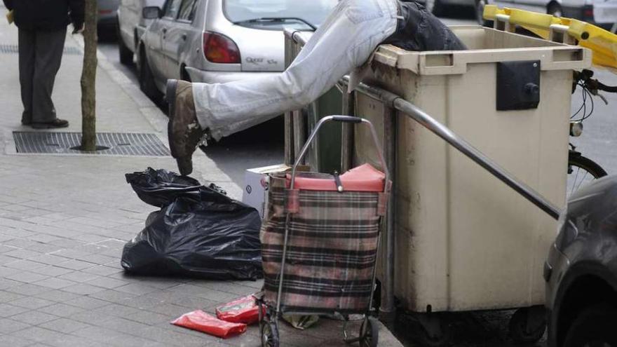 Una persona rebusca en la basura en A Coruña.