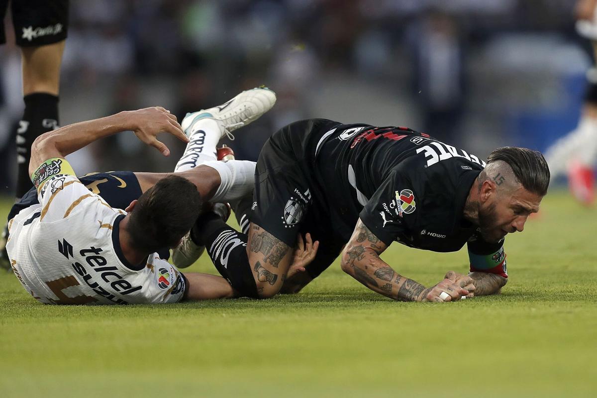Lisandro Magallán, de blanco, cae derribado tras disputar un balón con Sergio Ramos.