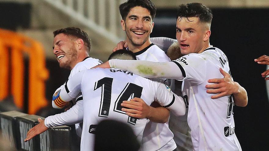 Manu Vallejo celebra el primer gol del Valencia CF, ya en el descuento, junto a varios compañeros. | F. CALABUIG/SD