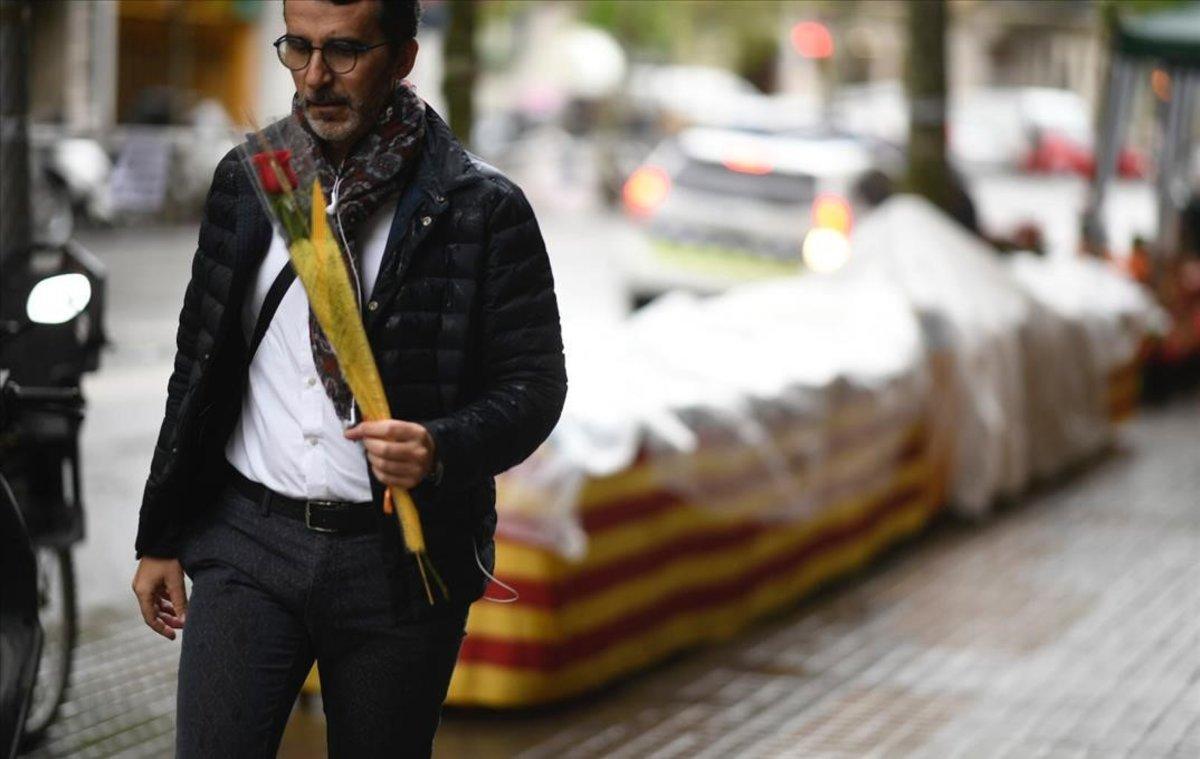 Un hombre lleva una rosa, en Barcelona.