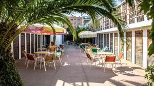 Mesas bajo la sombra en la terraza de Banys La Pista, en la playa de lEstació de Badalona.