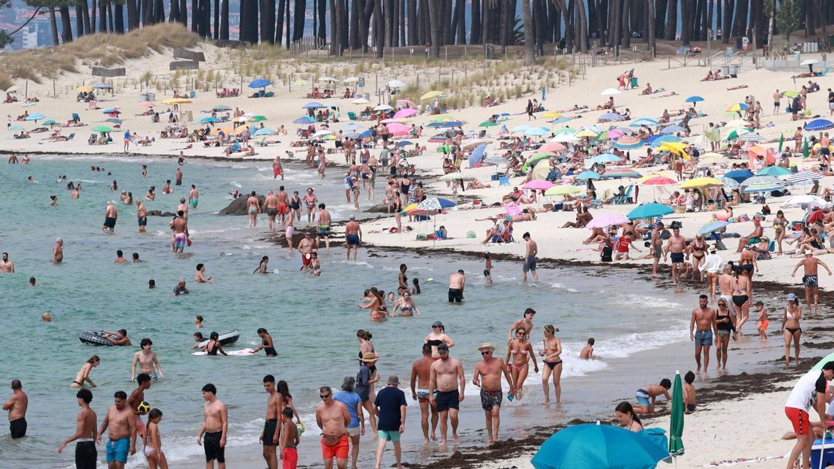 Bañistas disfrutando del día de playa de la buena temperatura del agua ayer en Samil.