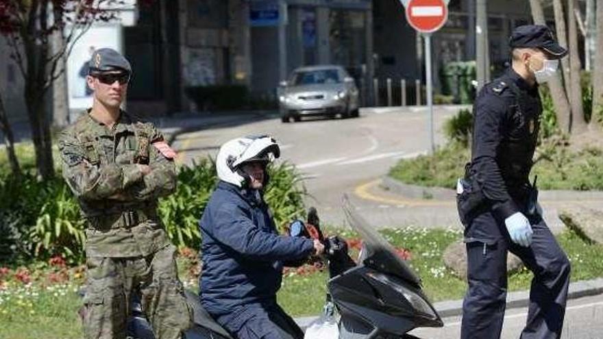 Dos militares de la Brilat y un policía ayer en la rotonda de Raíña Victoria con la Alameda. // Rafa Vázquez