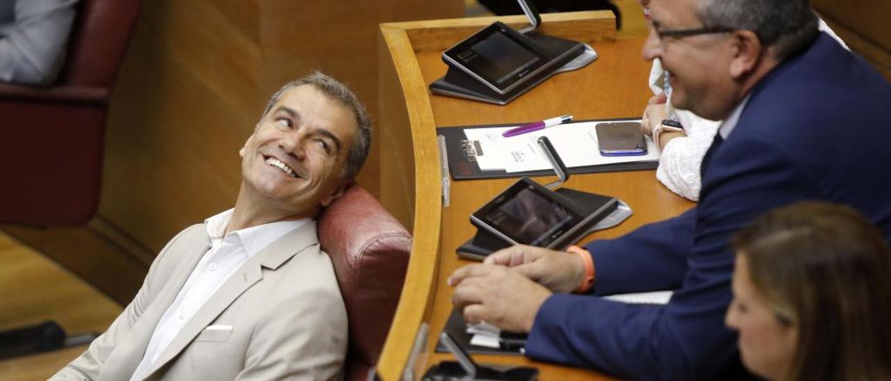 El síndic de Ciudadanos, Toni Cantó, se reclina sobre su escaño en las Corts junto a varios diputados.