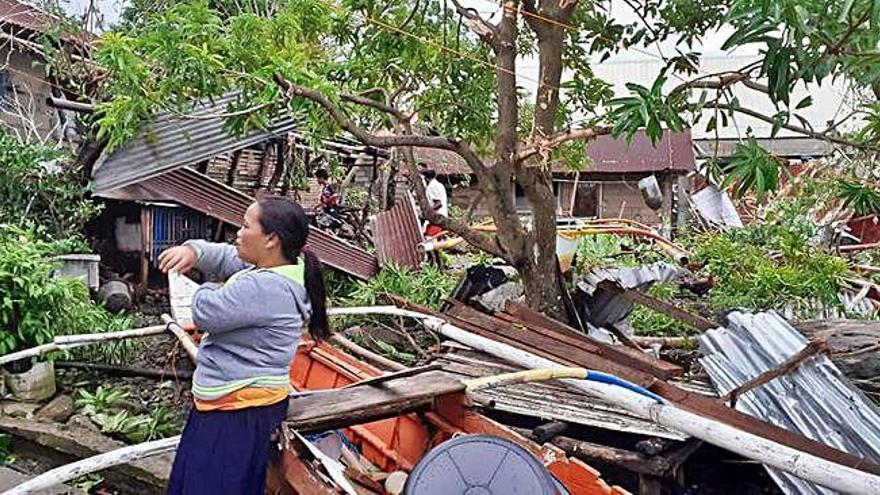 Una dona al costat d&#039;una casa en runes ahir a Bliran, Filipines