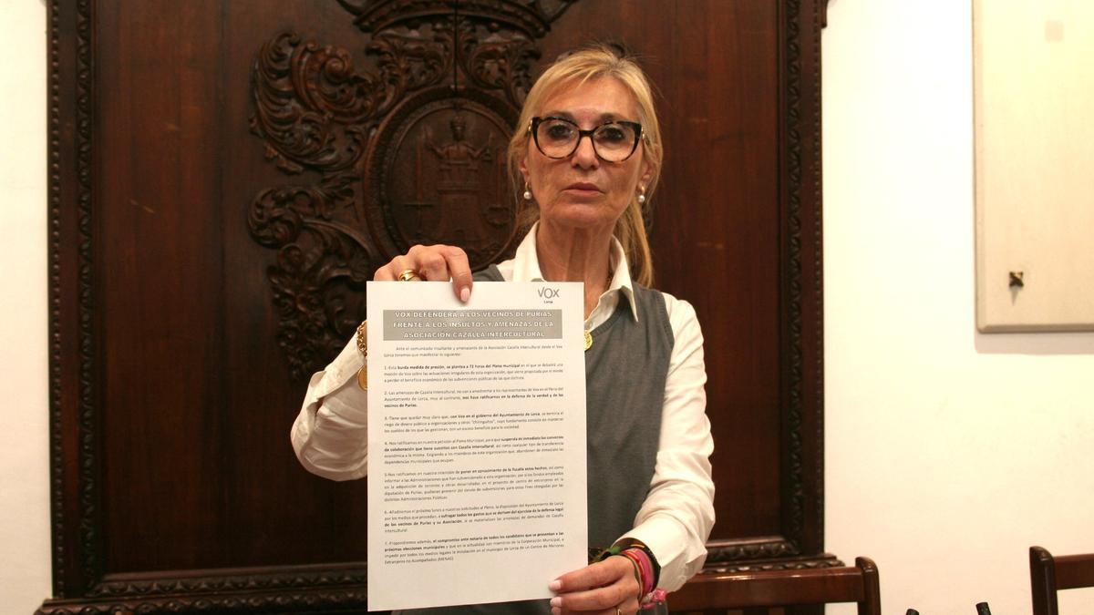 La portavoz de Vox, Carmen Menduiña, con el comunicado en defensa de los vecinos de Purias que leía durante la rueda de prensa, este viernes.