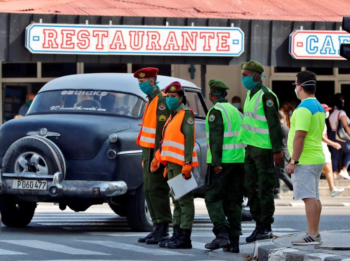 AME090. LA HABANA (CUBA), 03/04/2020.- Varios militares realizan labores de control, este viernes, en La Habana (Cuba). Una sección del céntrico barrio del Vedado, en La Habana, quedará aislada a partir de hoy viernes debido al número de contagios del coronavirus SARS-CoV-2 (causante de la enfermedad COVID-19) que acumula, informaron el pasado jueves medios estatales. EFE/ Ernesto Mastrascusa