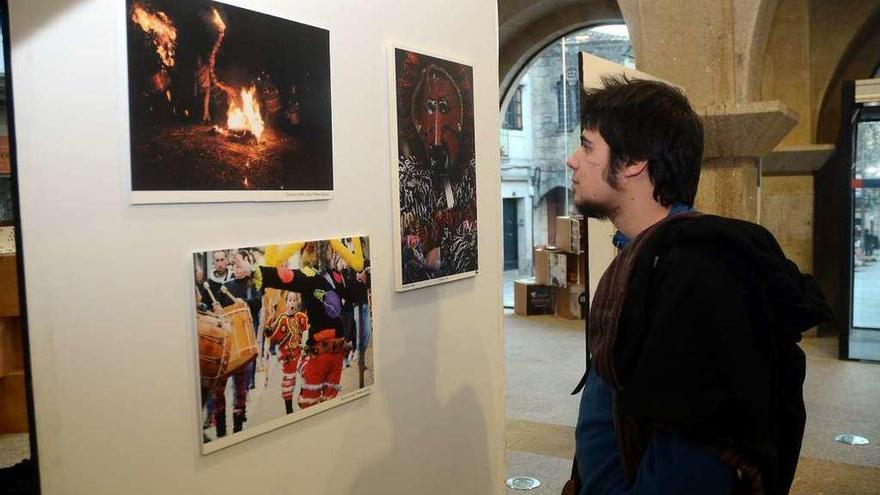 Un joven contempla una exposición sobre los Entroidos de Galicia. // Rafa Vázquez