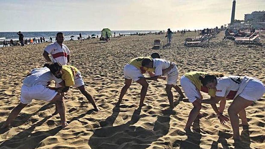 Varios jóvenes del proyecto &#039;Value of youth&#039; bregan en la playa de Maspalomas.