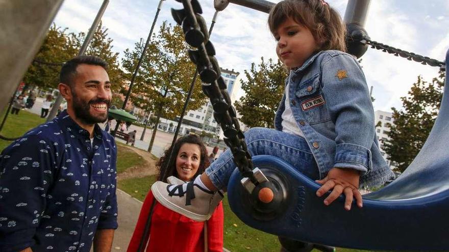 Javier García y Bea Outeiro miran cómo juega su hija Mía en el área infantil de Las Meanas.