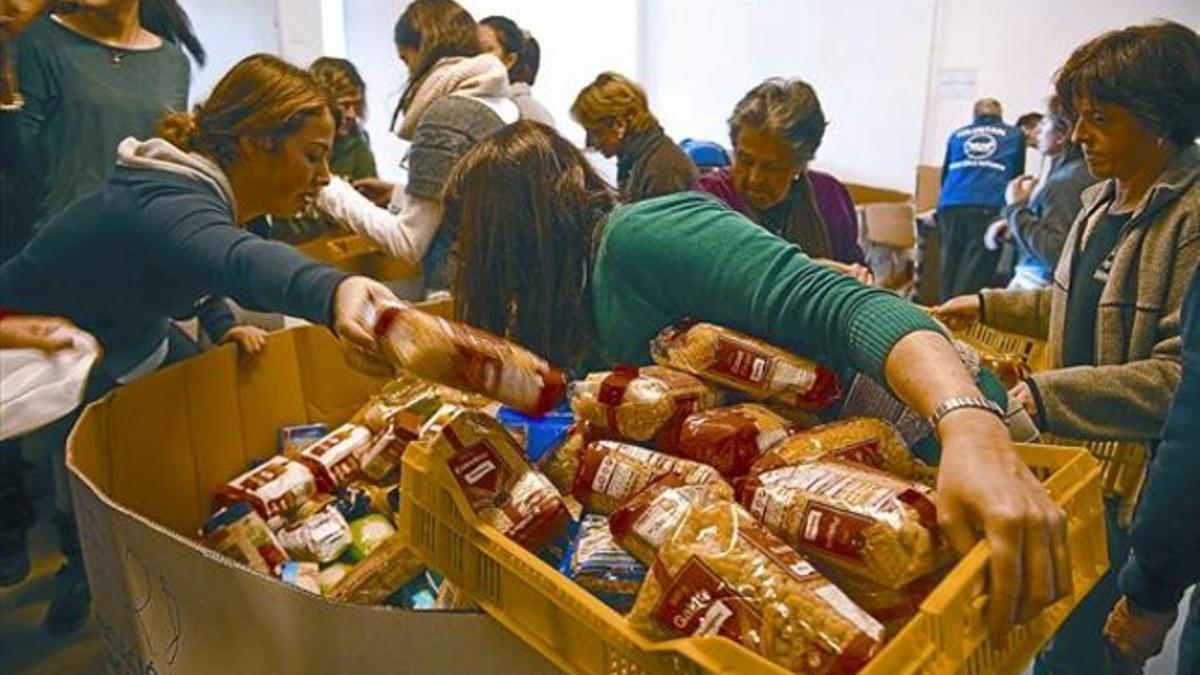 Unos voluntarios clasifican víveres procedentes del Gran Recapte en la sede del Banc dels Aliments, el 2 de diciembre.