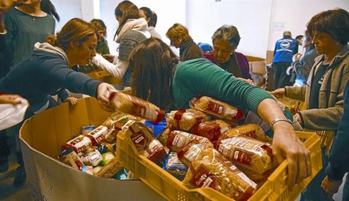 Uns voluntaris classifiquen queviures procedents del Gran Recapte a la seu del Banc dels Aliments, el 2 de desembre.