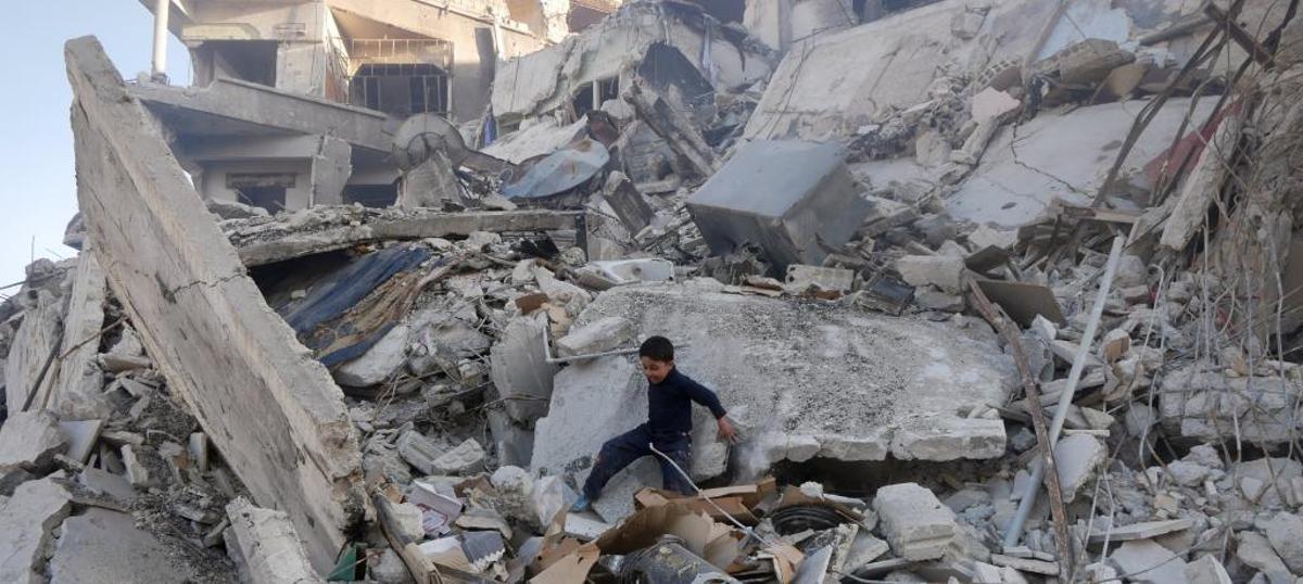 Un niño juega entre los escombros en Harasta, Guta.
