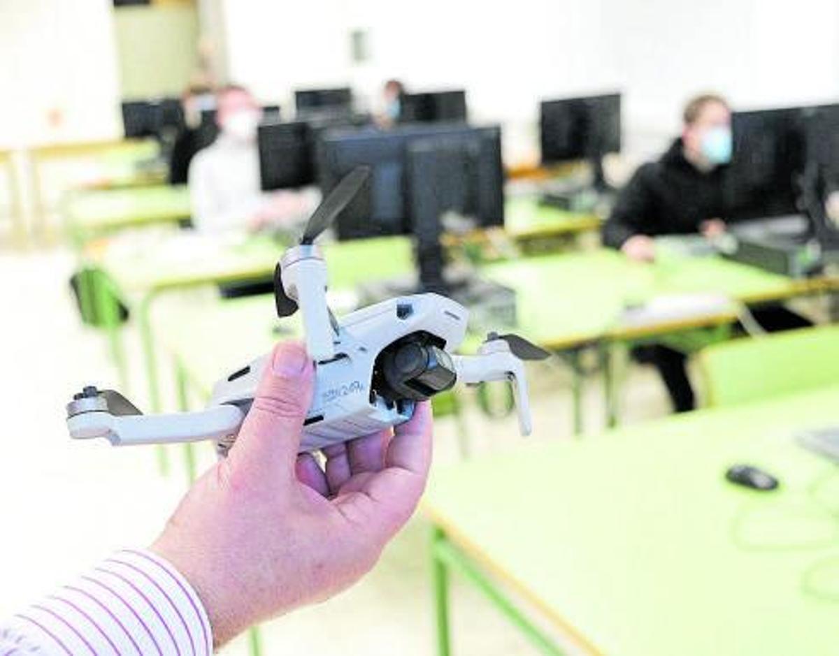 El profesor Vicente García muestra una de la aeronaves autónomas que estudian en las clases. Al lado, alumnado de Robótica que actualiza su formación aplicada a la industria 4.0. | PILAR CORTÉS