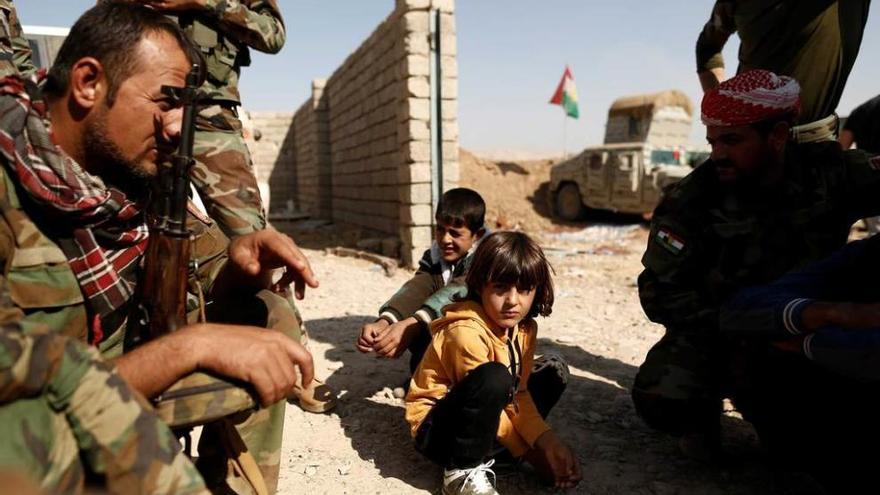 Niños iraquíes junto a varios &quot;peshmerga&quot; kurdos en una posición cercana a Bashiqa, al este de Mosul.