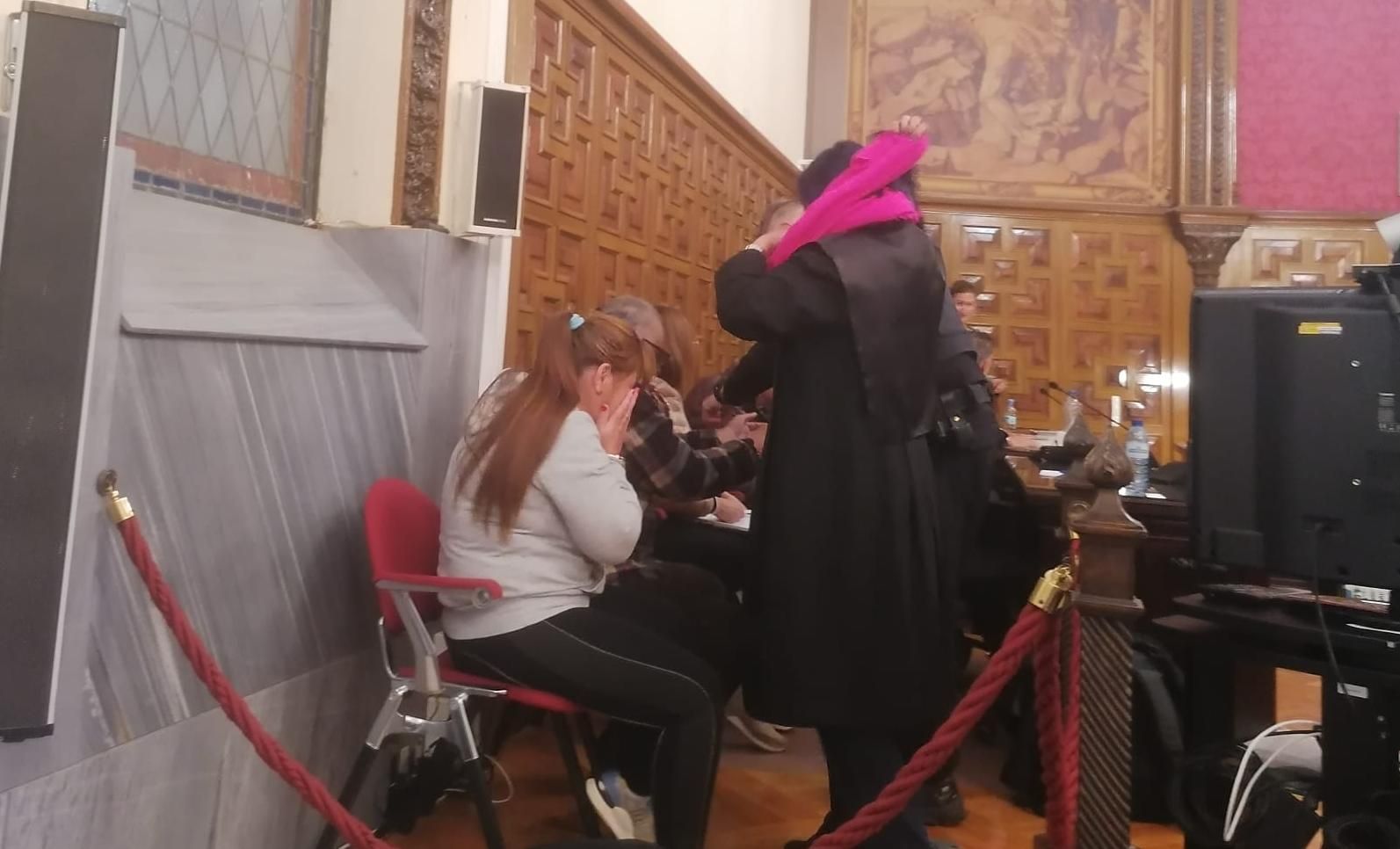 La condenada Ana Cristina P.A.S. se cubre la cara al conocer el veredicto del jurado junto a su expareja "Marineiro" (con camisa a cuadros), en la Audiencia de Zamora.