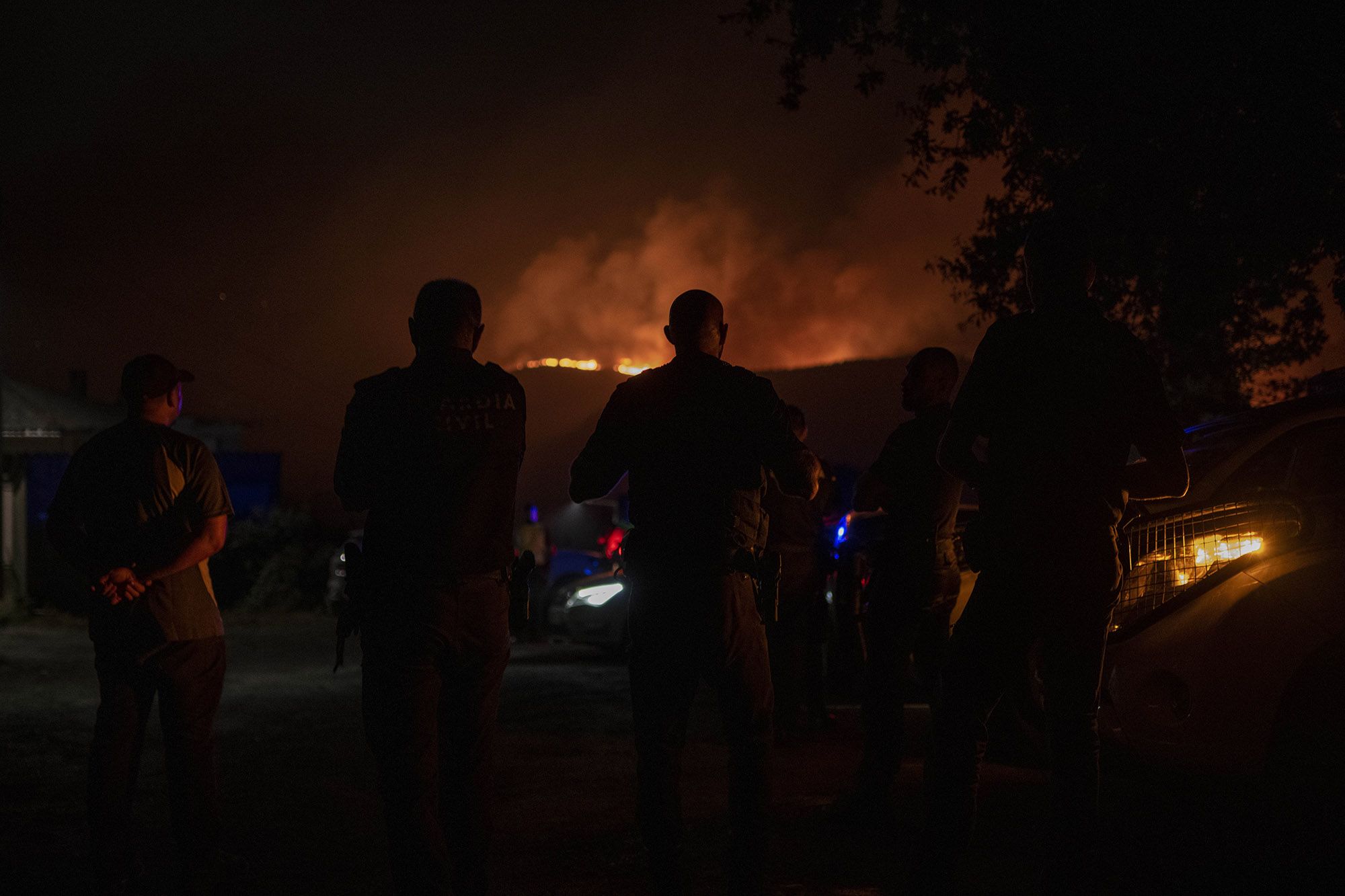 Vecinos y agentes durante la noche del miércoles al jueves, en el incendio de O Irixo, Dozón y Lalín