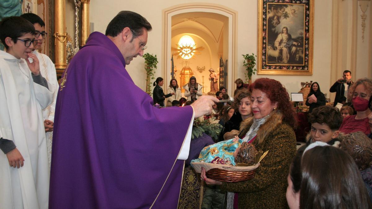 El párroco del Carmen, Juan José Torreglosa, bendice el Niño Jesús de una mujer, este domingo.