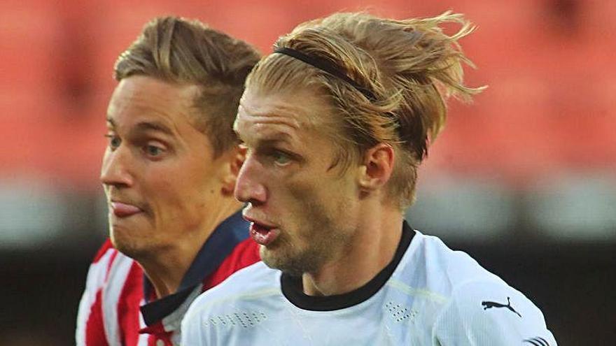 Daniel Wass pelea un balón contra el atlético Marcos Llorente.