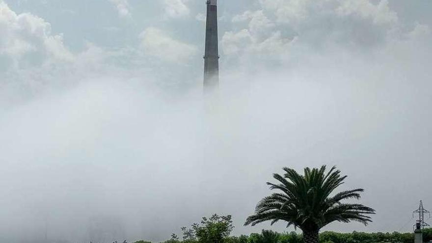 La chimenea de la central del polígono Sabón, cubierta por la niebla