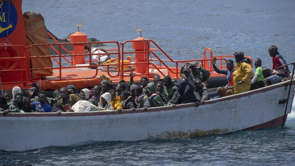 Un cayuco es remolcado por una embarcación de Salvamento Marítimo.