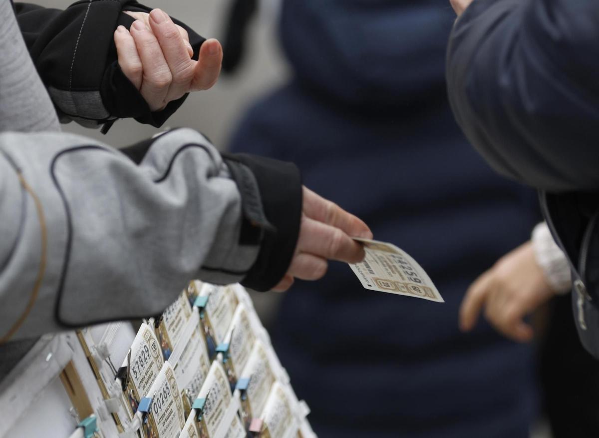 Una personas compra un décimo de lotería de Navidad a una vendedora ambulante cuando quedan menos de tres semanas para el Sorteo Extraordinario de la Lotería de Navidad, a 7 de diciembre de 2021, en Madrid (España). Como cada año, la Lotería de Navidad se Una personas compra un décimo de lotería de Navidad a una vendedora ambulante cuando quedan menos de tres semanas para el Sorteo Extraordinario de la Lotería de Navidad, a 7 de diciembre de 2021, en Madrid (España). Como cada año, la Lotería de Navidad se