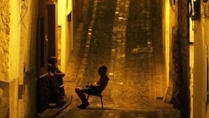 Varias personas toman el fresco por la noche en una calle del casco antiguo de Sagunto (Valencia).