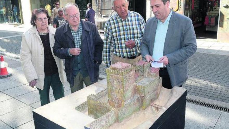 El concejal Luis Bará (dcha.) explica a unos vecinos la maqueta de las Torres Arzobispais. // Rafa Vázquez