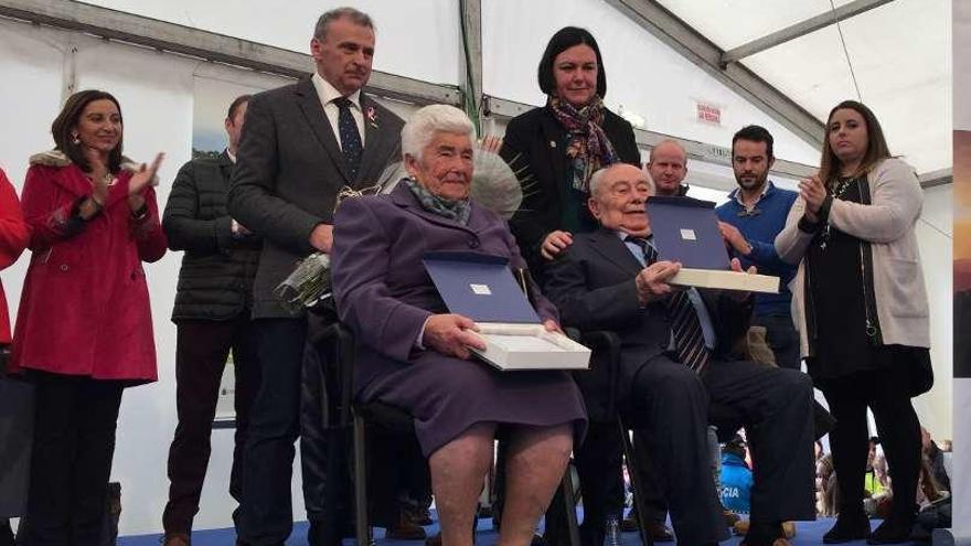 Joaquín Vázquez González, durante el pregón; a la derecha, sentados, Pacita Martino y Ramón Cavielles, &quot;Paisanos del año&quot;.