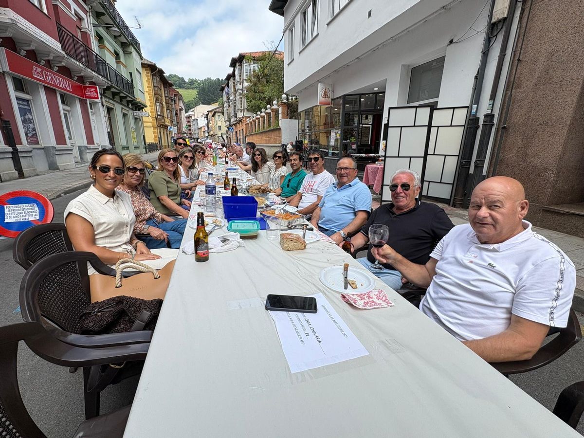 Vecinos de Tineo disfrutan de la comida en la calle.