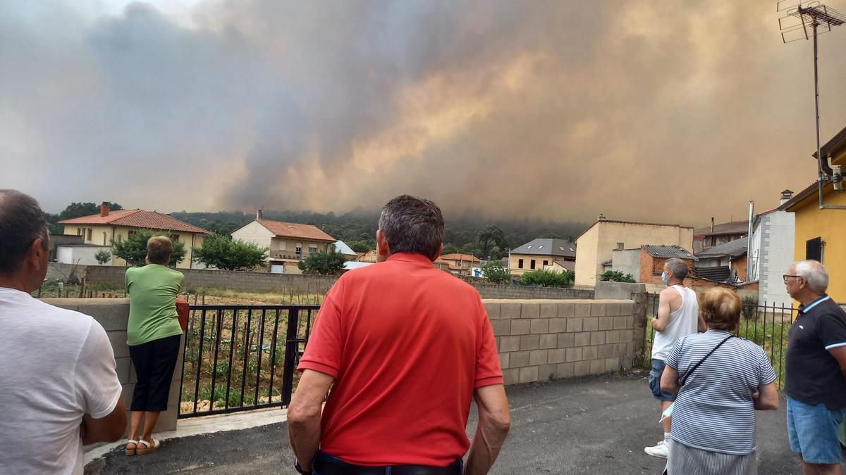 Los vecinos de Ferreras de Arriba, en la calle, miran el incendio desde la distancia.