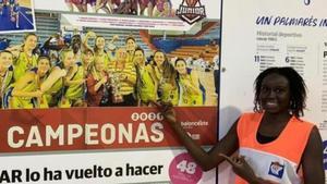 Adji Fall, sonriente en el Pabellón de La Paterna, señala una imagen de la plantilla campeona de España júnior de 2021