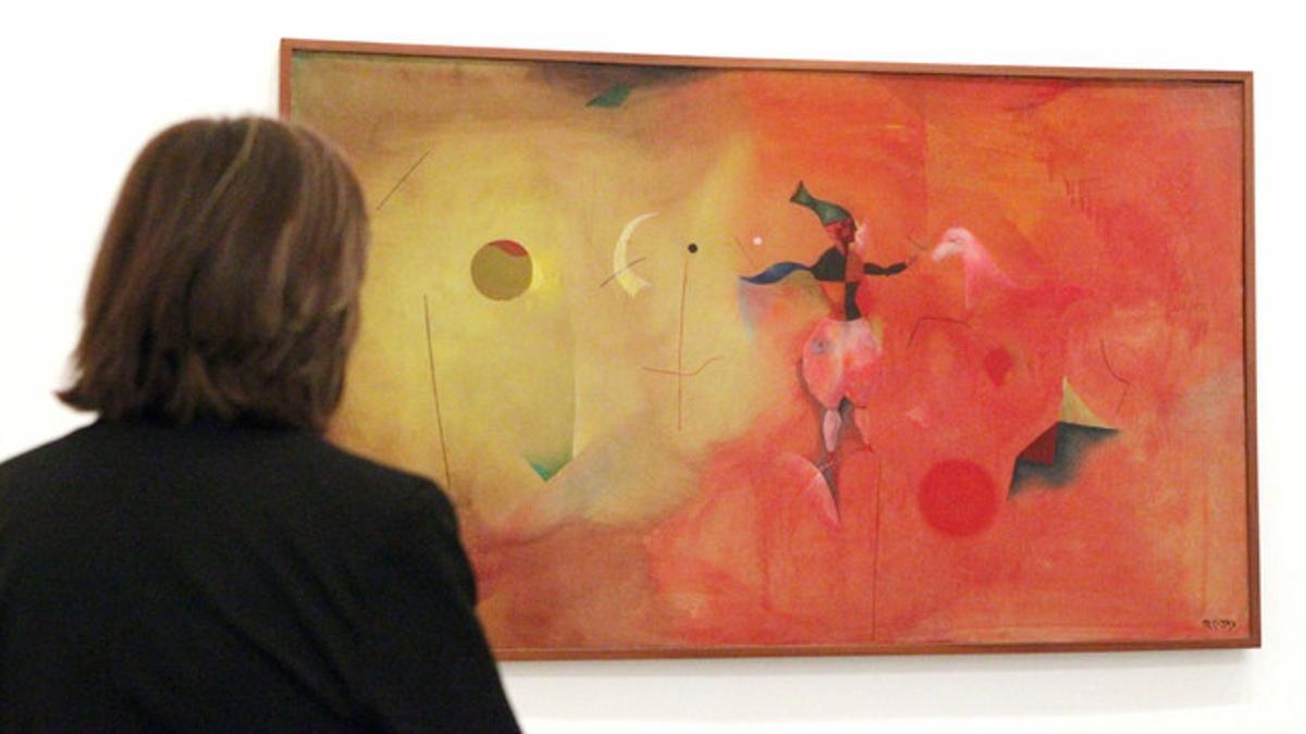 Una mujer observa el cuadro 'Circo', del pintor catalán Modest Cuixart, de la muestra 'El espejo invertido', este lunes en el Museo Guggenheim de Bilbao.