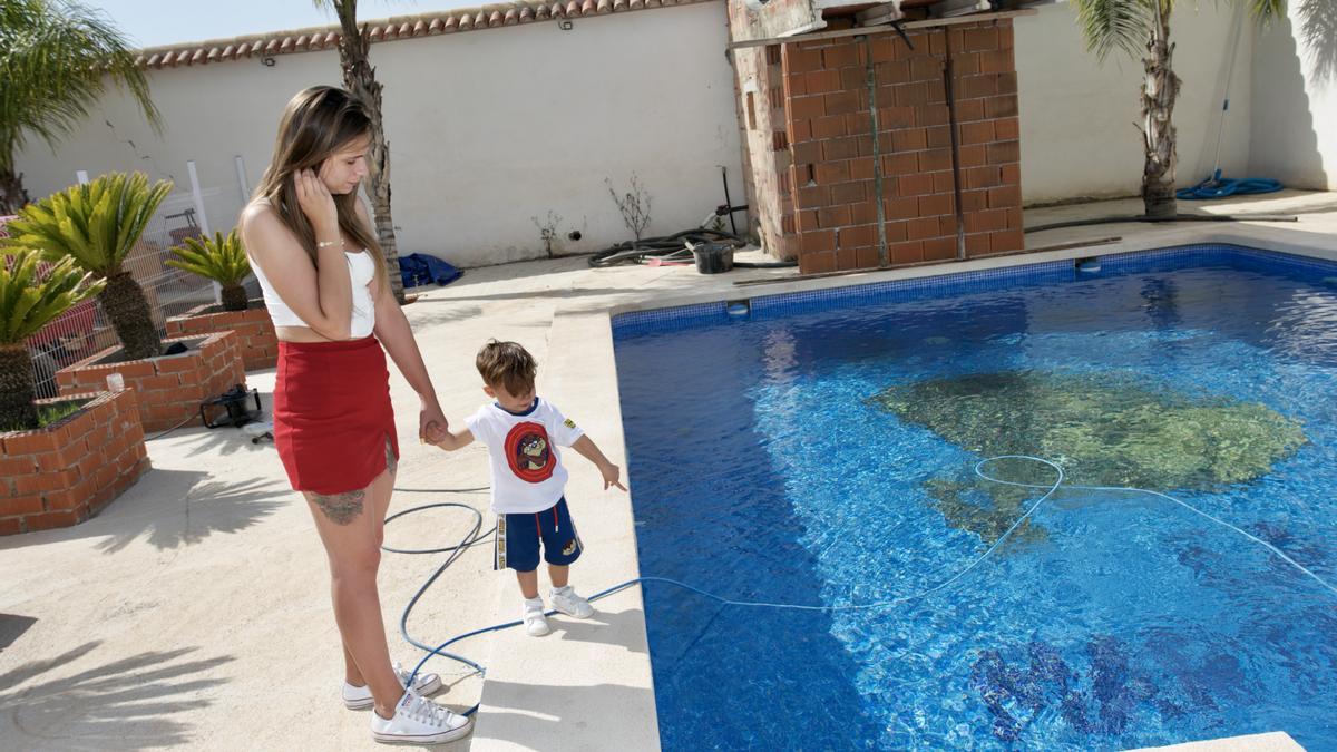 Manuel, de la mano de su madre y junto a la piscina de su casa de Sangonera, este lunes.